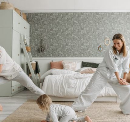 A joyful family bonding through morning stretches in a cozy bedroom setting.